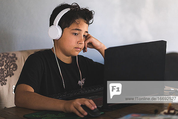 Junge macht seine Hausaufgaben am Laptop