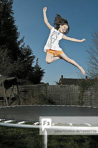 junges Mädchen springt auf einem Trampolin in Woking - England