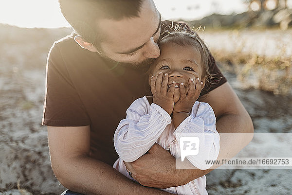 Nahaufnahme eines Vaters  der ein kleines Mädchen am Strand hält