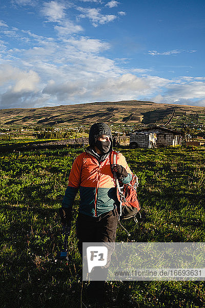 Junger Mann beim Wandern in den Anden mit Sonnenuntergang und Ausrüstung