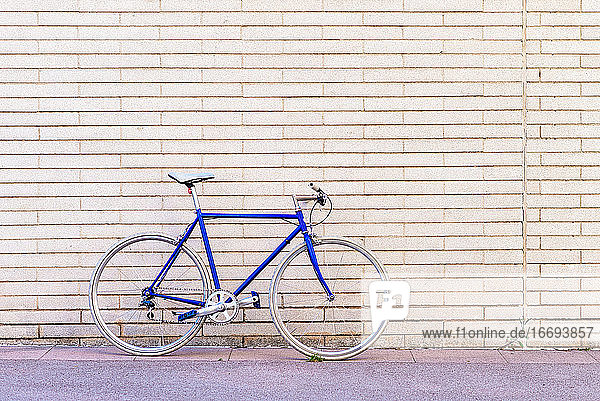 Vintage blauen Fahrrad lehnt an einer Stadt Backsteinmauer