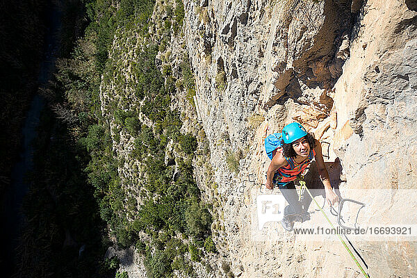 Junge Frau klettert durch einen Klettersteig in der Chulilla-Schlucht (Spanien)