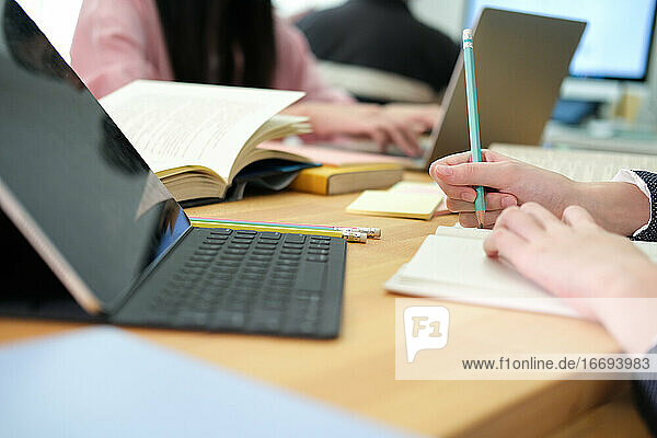 Junge Collage-Studentin beim Lernen mit Computer und digitalem Tablet