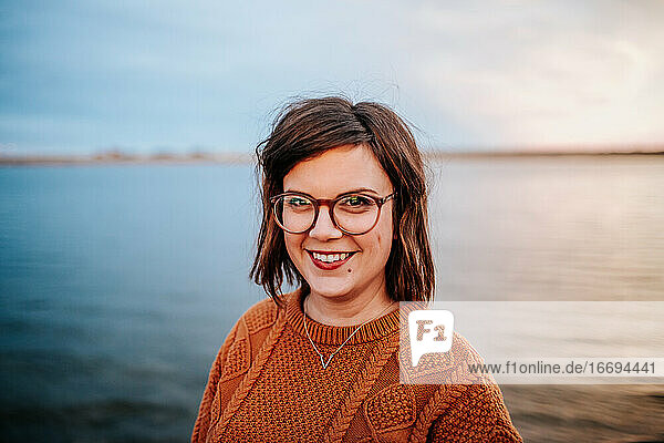 Mitte Porträt einer Frau mit Brille in der Nähe eines Sees
