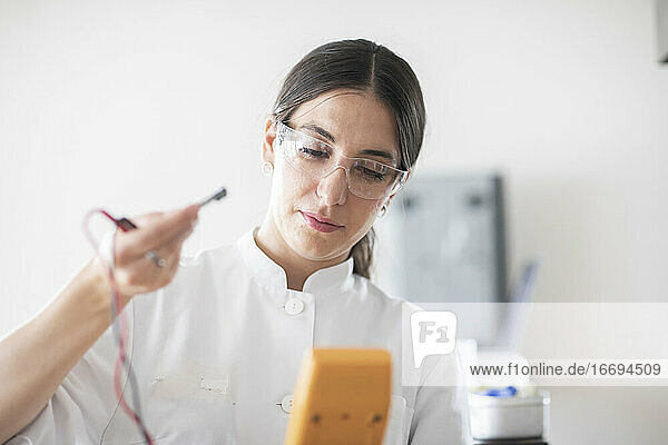 Wissenschaftlerin mit Laborbrille  Tablette und Probe in einem Labor