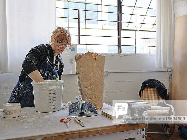 Professionelle Bildhauerin bei der Arbeit in ihrem Atelier
