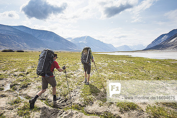 Rückansicht von Backpackers Wanderung über die arktische Tundra am Akshayak-Pass