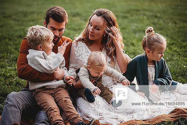 Schöne Familie sitzt in einem Park und schaut sich an einem Herbsttag an
