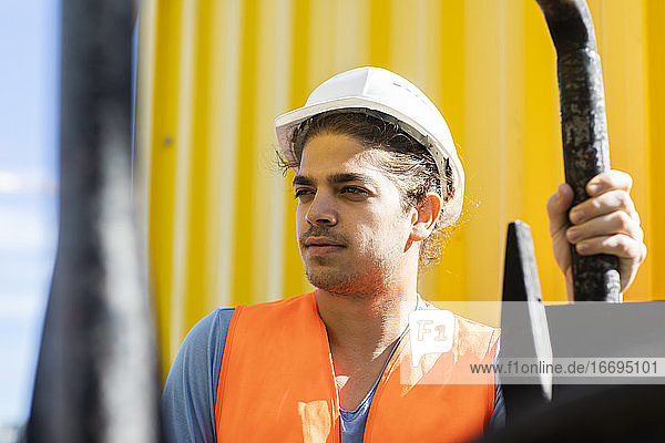 junger Bauingenieur mit Helm bei der Arbeit im Freien
