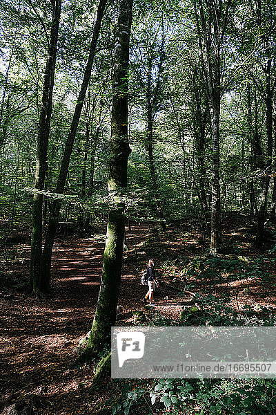 Mädchen mit Gesichtsmaske geht im Wald spazieren