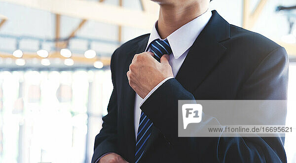 Businessman adjusting his neck tie.
