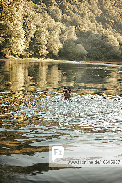Junger Mann beim Baden im Fluss