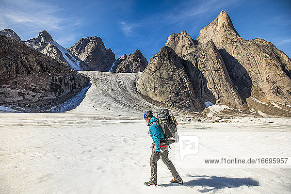 Backpacker hiking on glacier through Akshayak Pass  Baffin Island.