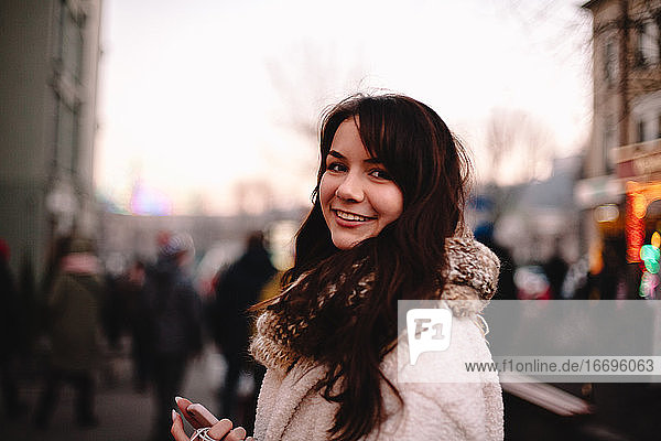Porträt eines glücklichen Teenagers in warmer Kleidung in der Stadt stehend