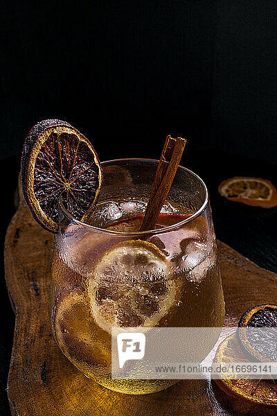 Gin-Tonic-Cocktail mit Zimt und Zitrone auf einem Holztisch