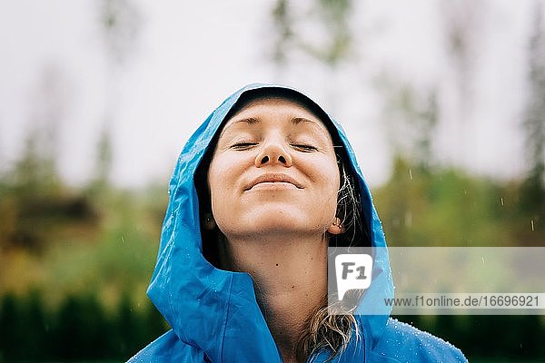 woman stood in the rain smiling with rain drops on her face