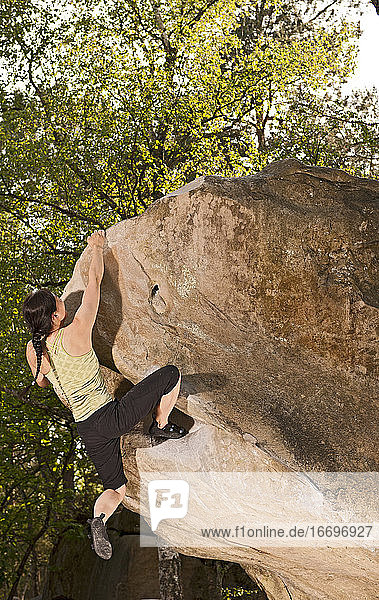 Reife Frau beim Bouldern im Wald von Fontainebleau in der Nähe von Paris