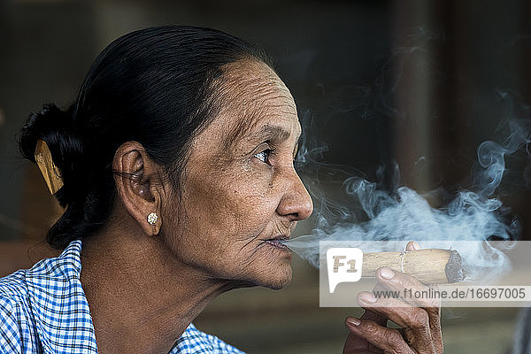 Nachdenkliche ältere birmanische Frau beim Zigarrenrauchen  Bagan  Myanmar