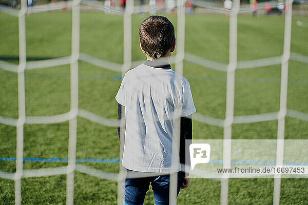 Rückansicht hinter dem Netz eines Kinderfußballtorwarts im Tor