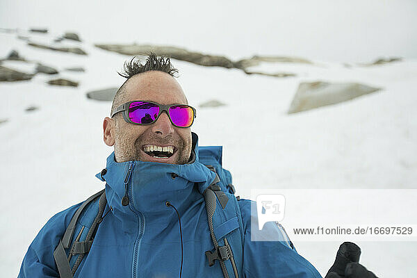 Der Bergsteiger Adam Palmer lacht im Freien.