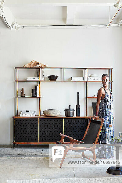 Portrait of woman in clean  modern living area with shelving
