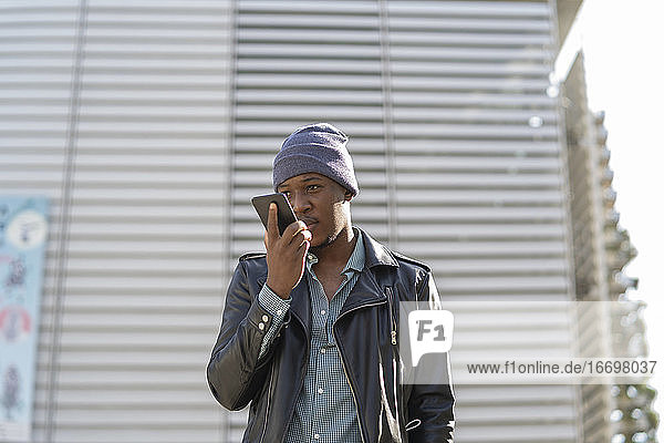 young african man in the city talking on his smartphone