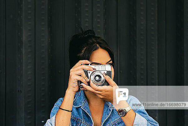 Frau mit industriellem Hintergrund beim Fotografieren  Kamera