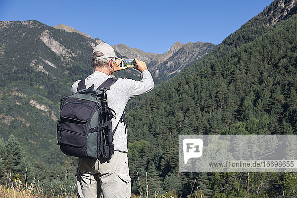 Mid alten kaukasischen Touristen Mann ein Bild von spanischen Pyrenäen Berg mit Handy nehmen