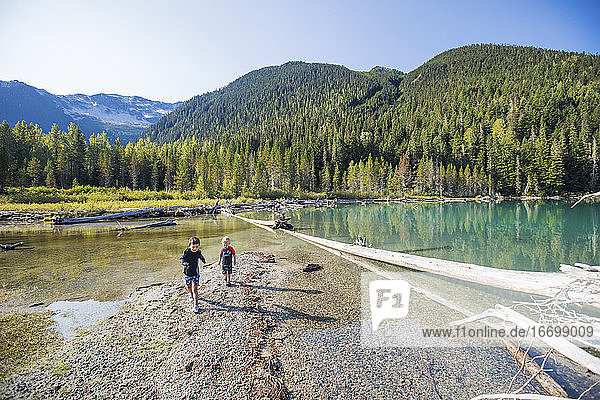 Two boys explore and play no remote beach in British Columbia  Canada