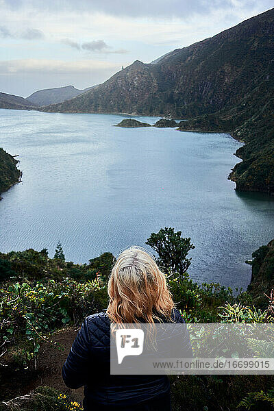 Junge blonde Frau  die den See 'do fogo' von Sao Miguel  Azoren  beobachtet