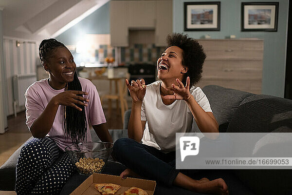Happy diverse girlfriends having pizza party