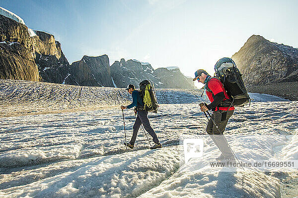 Backpackers hike across glacier on Baffin Island.