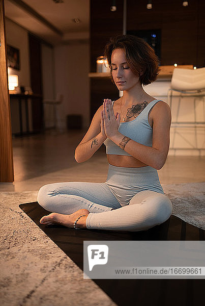 Junge Frau meditiert in Lotus-Pose