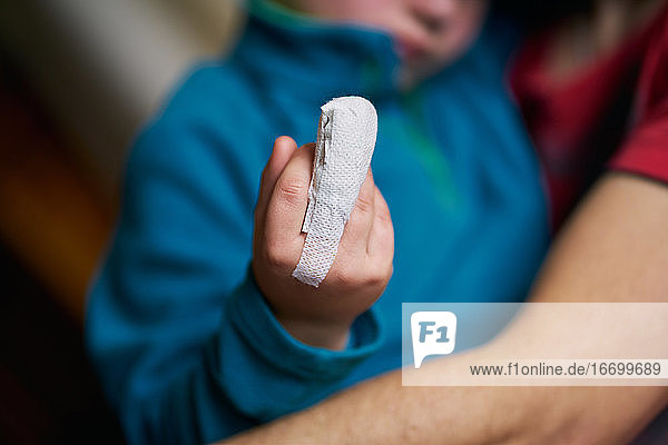 Ein Kind mit bandagiertem Finger