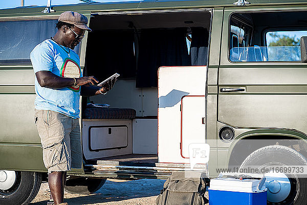 african american man typing on the tablet in a camping