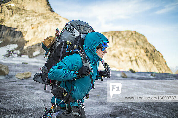 Bergsteiger hebt bei Gletscherüberquerung schweren Rucksack auf die Schultern