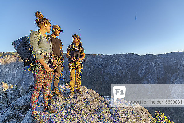Drei Wanderer auf dem Gipfel des El Capitan im Yosemite Valley bei Sonnenuntergang