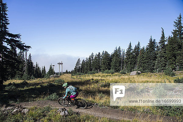 Eine junge Frau fährt an einem sonnigen Tag am Mt. Hood  Oregon  mit dem Fahrrad.