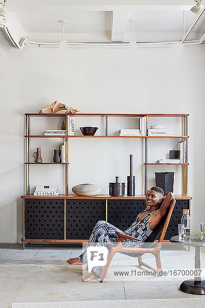 Portrait of woman in clean  modern living area with shelving