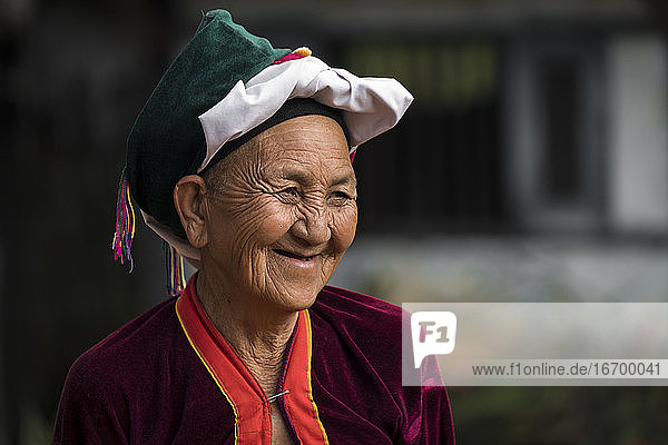Porträt einer lächelnden älteren Frau vom Stamm der Palong mit Kopfbedeckung  in der Nähe von Hsipaw  Myanmar