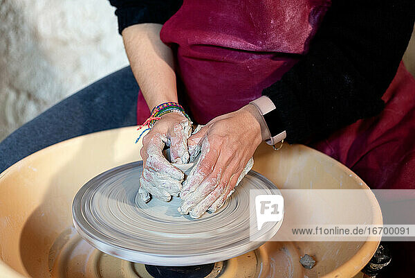 Keramikkünstlerin bei der Arbeit in ihrem Atelier mit der Töpferscheibe