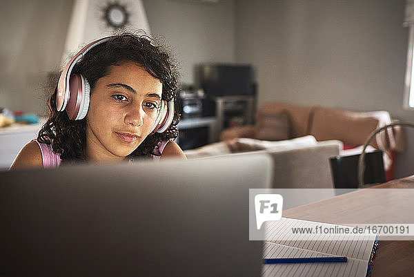 Nahaufnahme eines Mädchens mit Kopfhörern bei der Arbeit mit ihrem Laptop