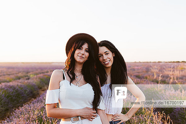 Girlfriends smiling and looking at the camera in a lavender field