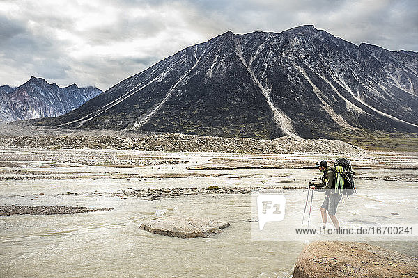 Hiker faces adversity  crossing a braided river channel.
