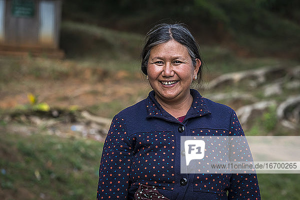 Lächelnde reife Frau vom Stamm der Palong  die im Freien steht  in der Nähe von Hsipaw  Myanmar
