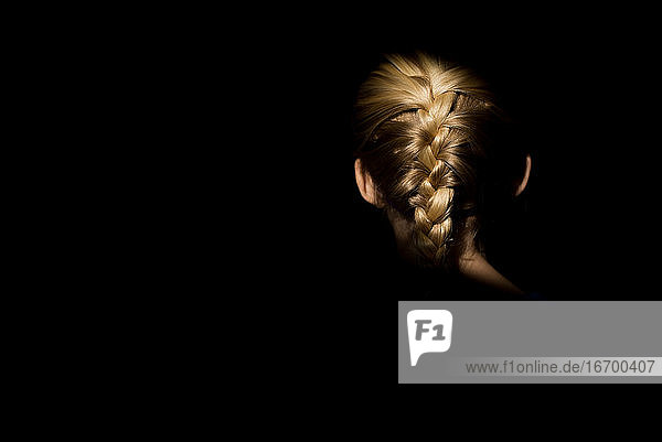Blonde girl braid in light with dark background