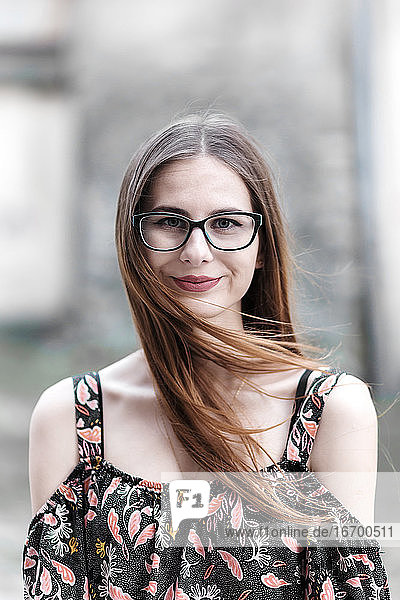 junge braunhaarige Millennials mit Brille und hellem Kleid