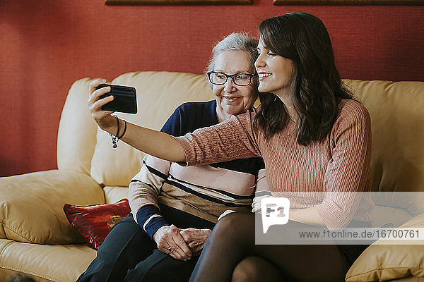granddaughter and grandmother taking a selfie on the sofa