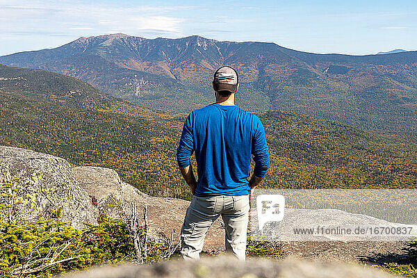 Man staring out at mountain ridge in the White Mountains of NH.