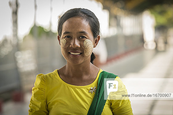 Porträt einer lächelnden Frau mit Blattzeichen im Gesicht  hergestellt von Thanaka  Mandalay  Myanmar